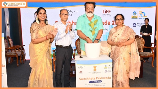 Suresh Gopi planting a sapling on stage at a Swachhata Pakhwada 2026 event at Amrita Vidyalayam, Perumbavoor